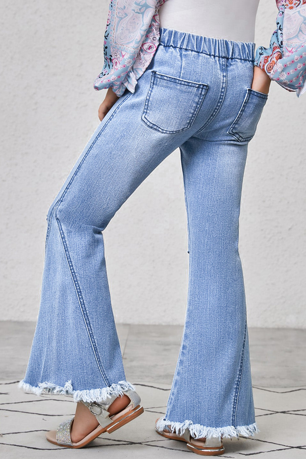 Jeans acampanados con ribete deshilachado para niñas